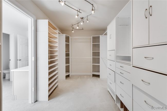 Primary walk-in closet featuring custom built shelving | Image 31