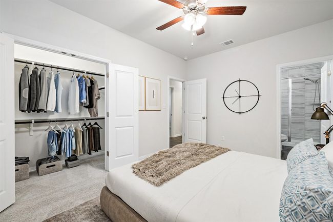 Carpeted bedroom featuring visible vents, a closet, connected bathroom, and a ceiling fan | Image 14