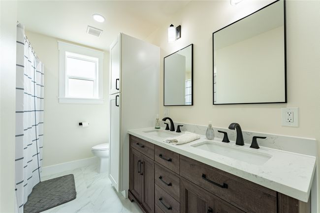 Full bathroom featuring toilet, marble finish floor, a sink, and visible vents | Image 11