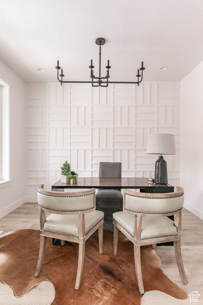 Dining area with a textured ceiling, an inviting chandelier, and light hardwood / wood-style flooring | Image 6