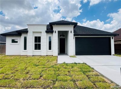 View of front facade with a garage and a front lawn | Image 1