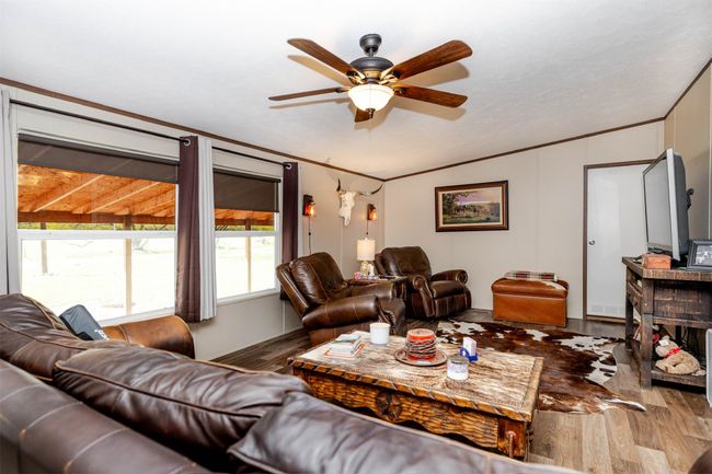 Living room featuring crown molding, ceiling fan, and wood finished floors | Image 17