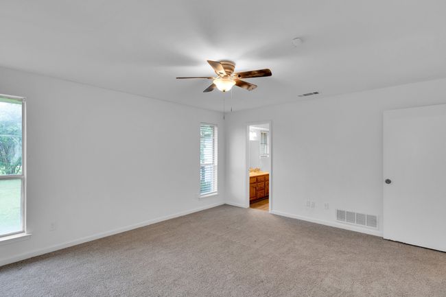 Spare room with ceiling fan, visible vents, light carpet, and baseboards | Image 26