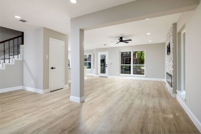 Unfurnished living room featuring light wood-type flooring, stairs, a ceiling fan, and recessed lighting | Image 9