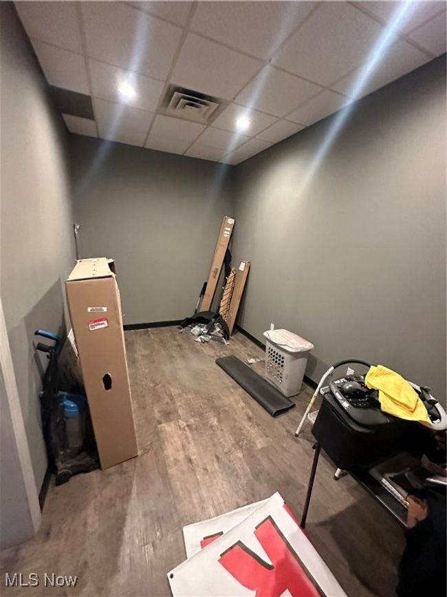Miscellaneous room with a drop ceiling and wood-type flooring | Image 12
