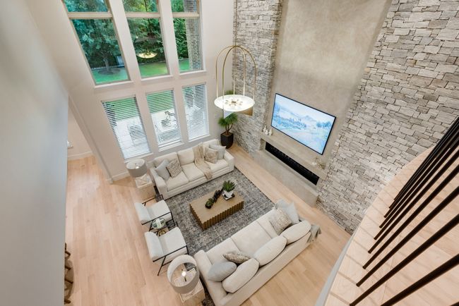 Living room with a towering ceiling, wood finished floors, and baseboards | Image 22