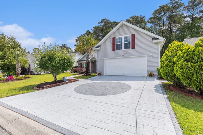Traditional-style home with curved driveway, a garage, and a front lawn | Image 6