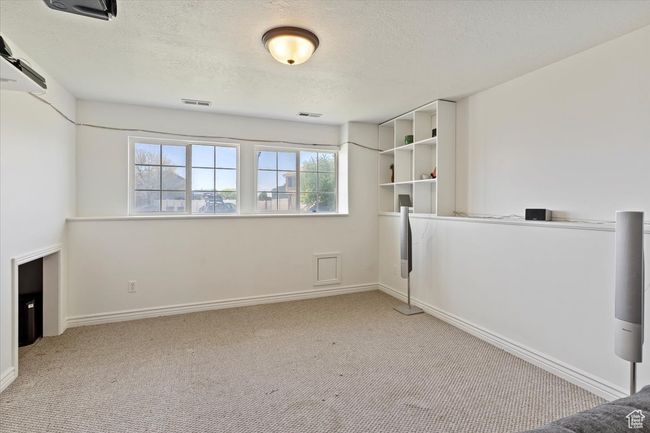 Living area with carpet, a textured ceiling, and baseboards | Image 20