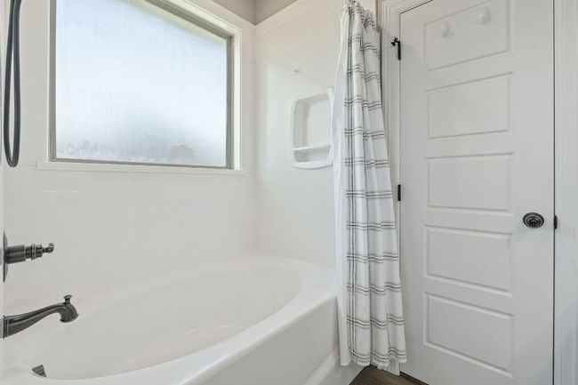 Full bath featuring a tub to relax in and a shower with curtain | Image 23