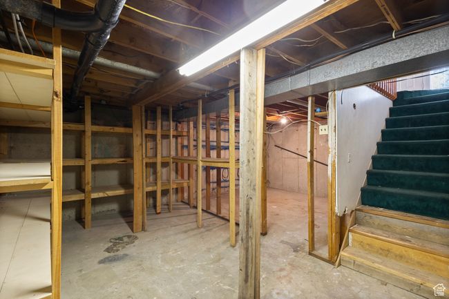 Unfinished basement featuring stairway and storage. | Image 31