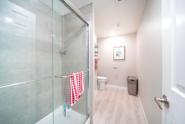 Bathroom featuring toilet, baseboards, a stall shower, visible vents, and wood finished floors | Image 30