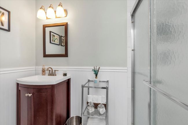 Full bathroom with a wainscoted wall, a shower with shower door, and vanity | Image 8