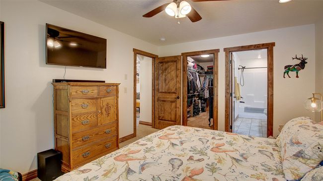 Bedroom with a walk in closet, baseboards, a closet, ensuite bath, and carpet | Image 19