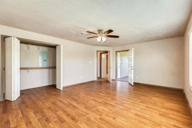 This view of the Primary Bedroom shows the closet to the left and the door to the Sunroom straight back on the right. Primary Bedroom is approximately 19'2" x 14'8". Buyer to verify all room measurements. | Image 37