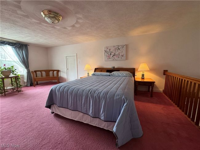 Carpeted bedroom with a textured ceiling and baseboards | Image 28