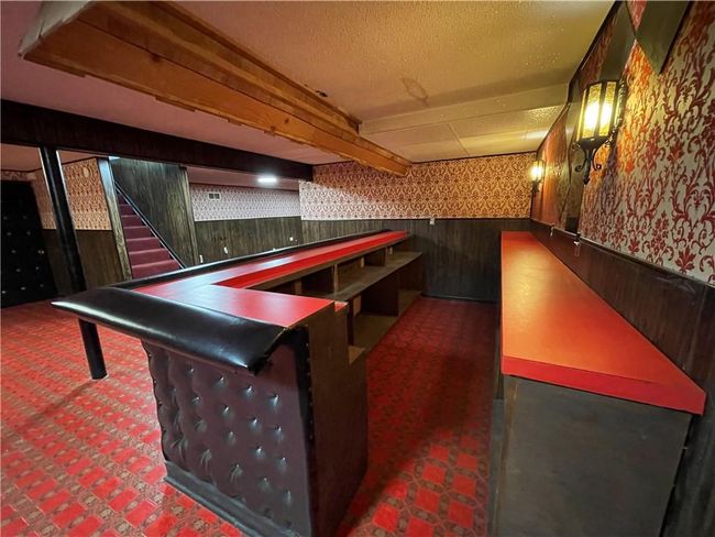 Playroom featuring carpet floors, wallpapered walls, a wainscoted wall, a textured ceiling, and a dry bar | Image 25