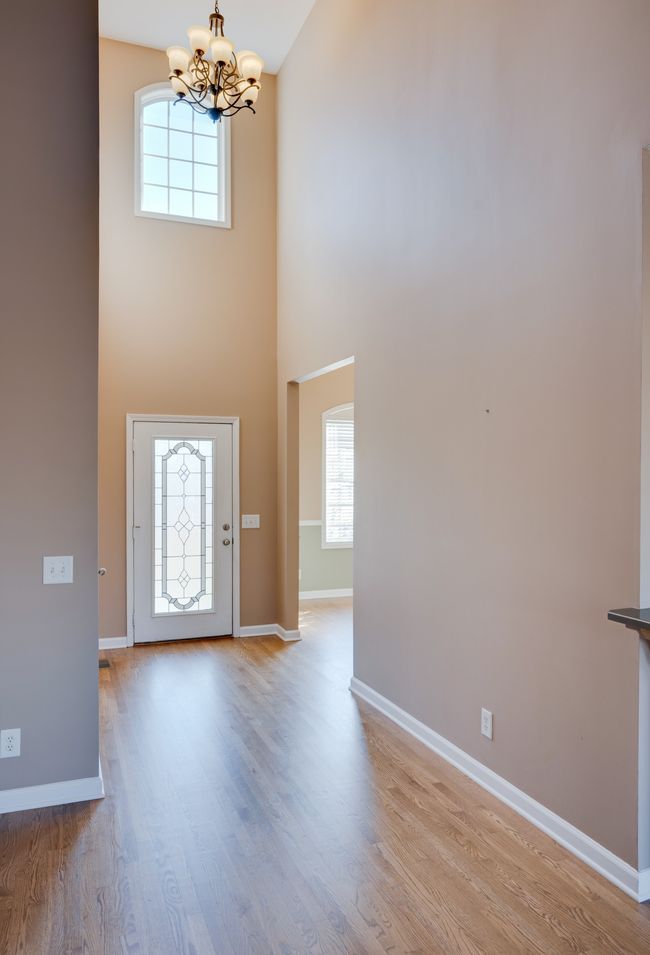 Vaulted ceiling in the entryway boasts a beautiful chandelier. | Image 5