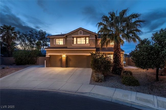 View of front of home with an attached garage, driveway, and stucco siding | Image 46