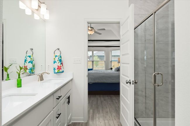 Ensuite bathroom with a sink, wood finished floors, ensuite bath, a shower stall, and double vanity | Image 10
