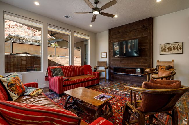 Living room featuring recessed lighting, a textured ceiling, visible vents, a ceiling fan, and a fireplace | Image 9