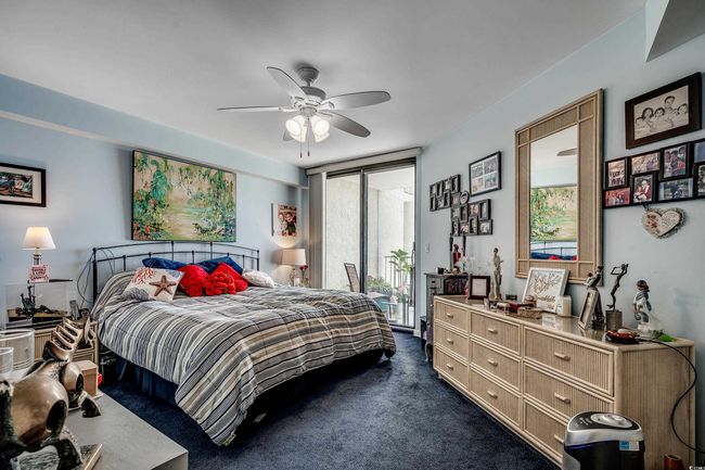 Bedroom with access to outside, a wall of windows, dark colored carpet, and a ceiling fan | Image 14