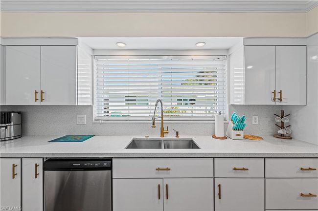 Kitchen with dishwasher, ornamental molding, a sink, and white cabinetry | Image 22