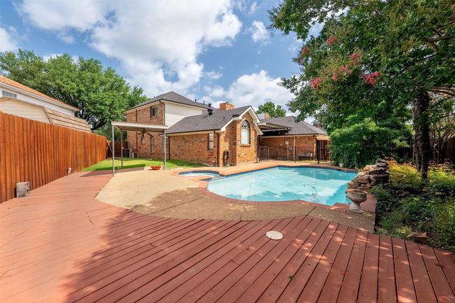 View of swimming pool featuring a fenced backyard, a pool with connected hot tub, a deck, and a patio | Image 28
