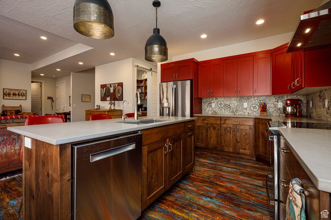 Kitchen with recessed lighting, backsplash, a center island with sink, a sink, and appliances with stainless steel finishes | Image 13
