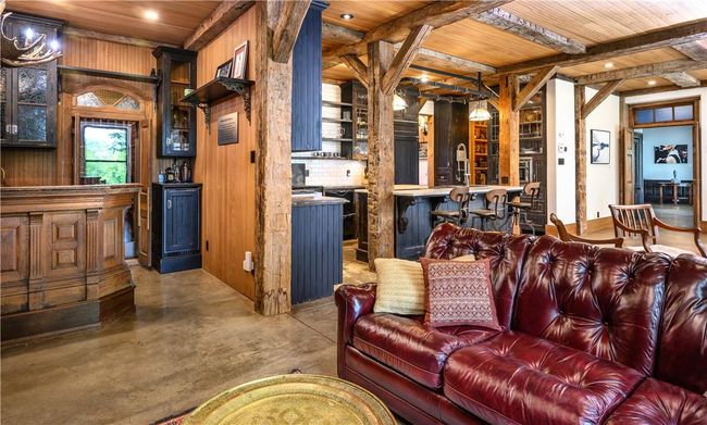 Living room with beamed ceiling, concrete floors, wood ceiling, and wood walls | Image 7