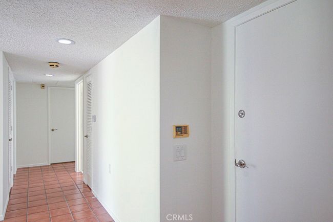 Hallway leading to the bedrooms and bathrooms. Front door at right. | Image 17