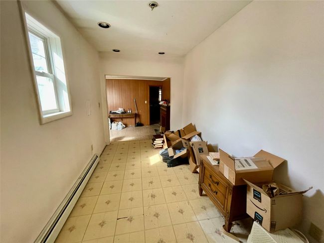 Corridor with a baseboard heating unit and light floors | Image 11