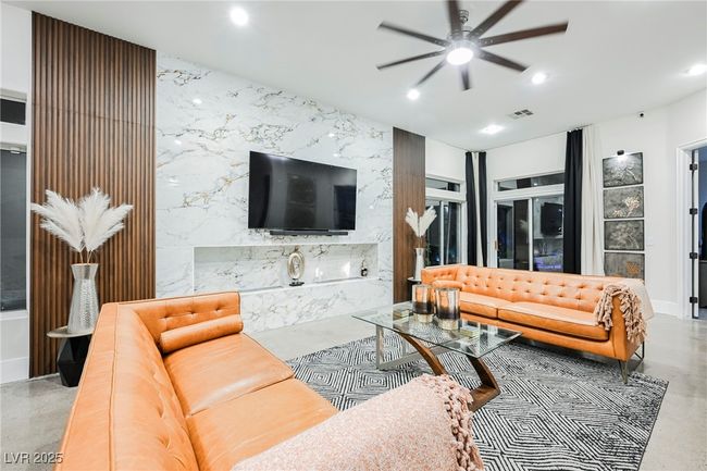 Living area with recessed lighting, a ceiling fan, visible vents, an accent wall, and finished concrete floors | Image 19