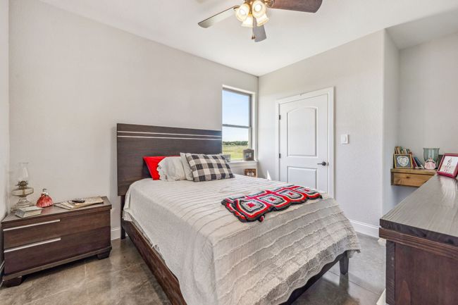 Bedroom with concrete floors, baseboards, and a ceiling fan | Image 20