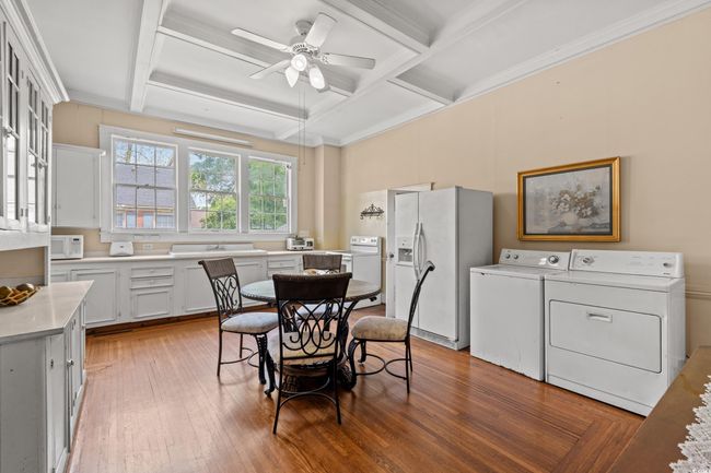 Dining room with independent washer and dryer, a ceiling fan, coffered ceiling, light wood-type flooring, and ornamental molding | Image 11