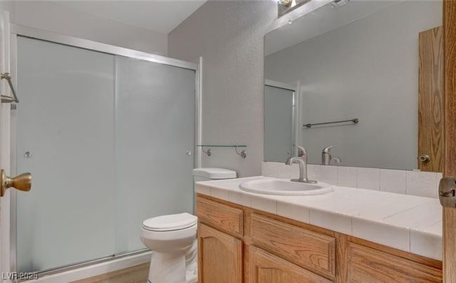 Bathroom with toilet, vanity, a stall shower, and wood finished floors | Image 9