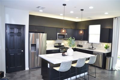 Contemporary designed kitchen with quartz counters and large island. | Image 3