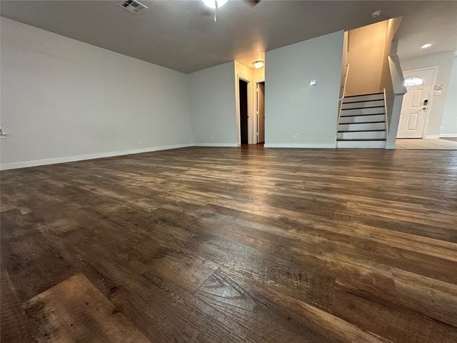 Unfurnished living room featuring stairs and wood finished floors | Image 22