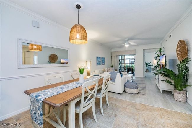 Dining space featuring custom light fixture, crown molding, and tile floors (dining table expands) | Image 9