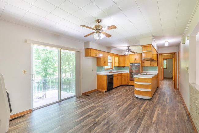Unfurnished living room with heating unit, wood finished floors, ceiling fan, and baseboards | Image 8