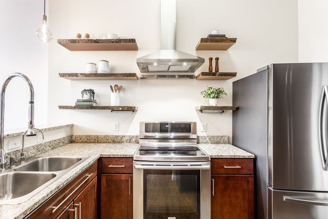 kitchen with stainless steel appliances, wall chimney range hood, and open shelves | Image 15