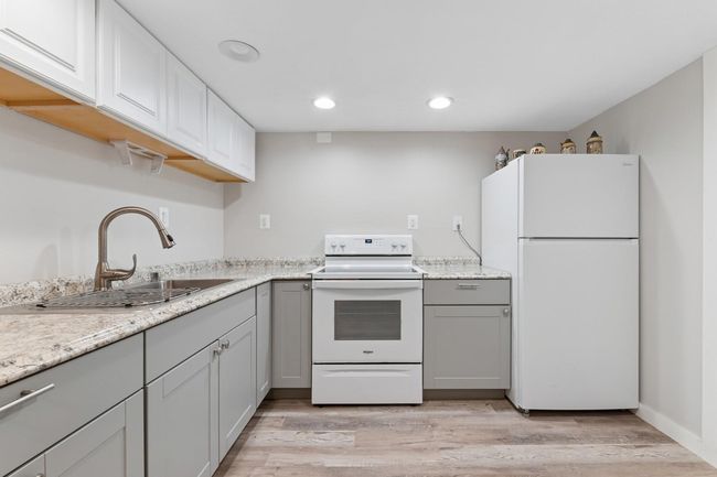 Kitchenette with a sink, light wood-style flooring, white appliances, and gray cabinetry | Image 20