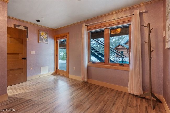 Empty room featuring baseboards, visible vents, a textured wall, ornamental molding, and wood finished floors | Image 53