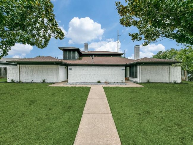 Rear view of house with a chimney, a yard, and brick siding | Image 14