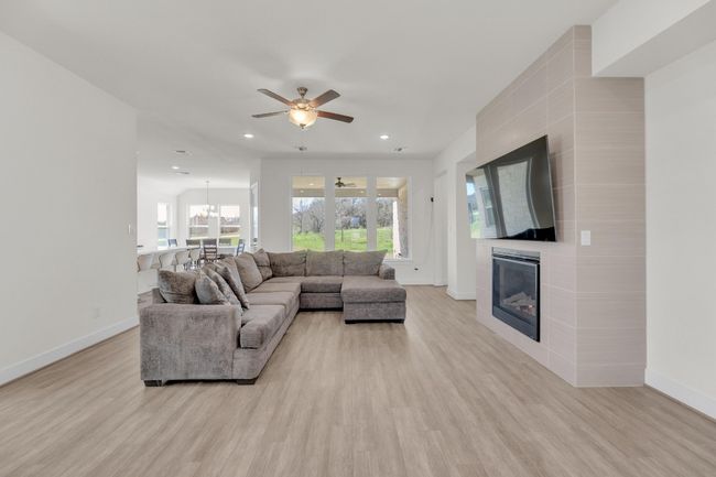 Living area featuring light wood-style floors, recessed lighting, a fireplace, and baseboards | Image 8