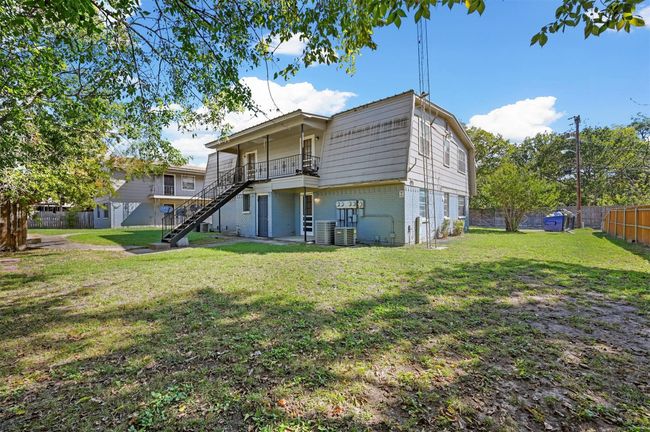 Rear view of house featuring stairs, brick siding, and a fenced backyard | Image 17