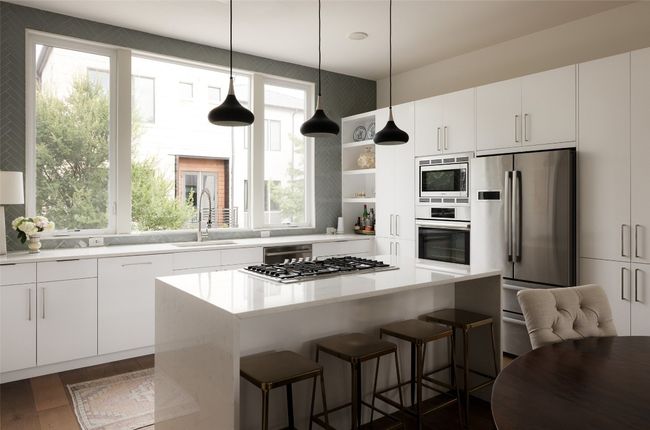 Kitchen featuring appliances with stainless steel finishes, open shelves, a center island, and healthy amount of natural light | Image 15