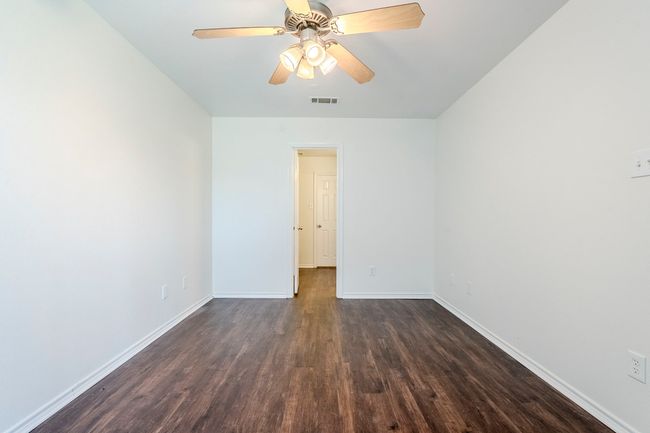 Spare room with dark wood-style flooring and ceiling fan | Image 13