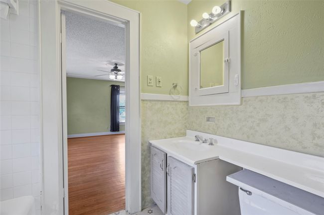Bathroom featuring vanity, ceiling fan, wainscoting, wood finished floors, and toilet | Image 13