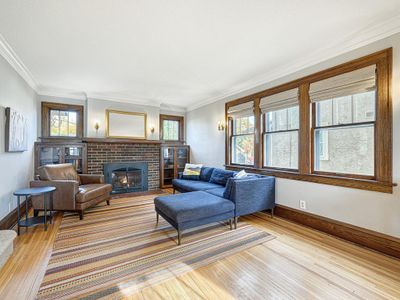 The living room has a gas fireplace and beautiful hardwood floors. | Image 3