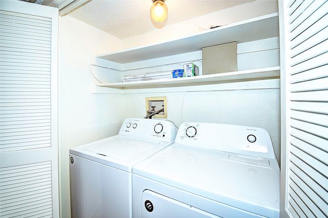 Clothes washing area with a textured ceiling and washing machine and clothes dryer | Image 26